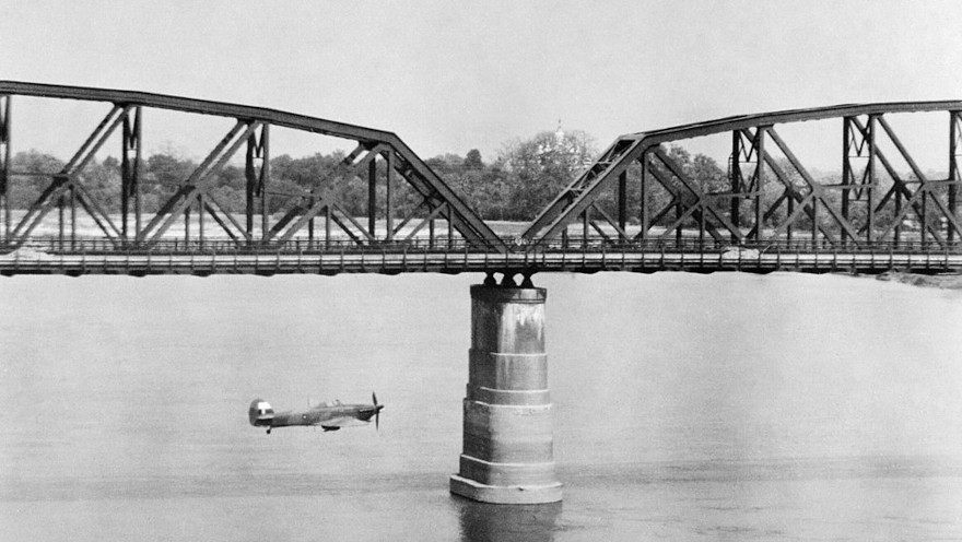 An RAF Hawker Hurricane flies alongside Ava Bridge, Burma, during a low-level reconnaissance sortie, March 1945. Public Domain Image.