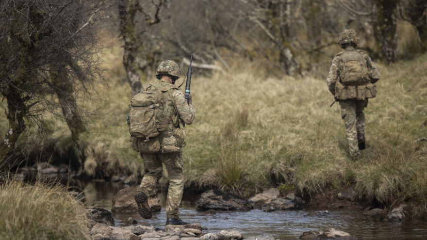 Soldiers cross a stream during Live firing ranges for students of the Light Close Reconnaissance Commanders course.