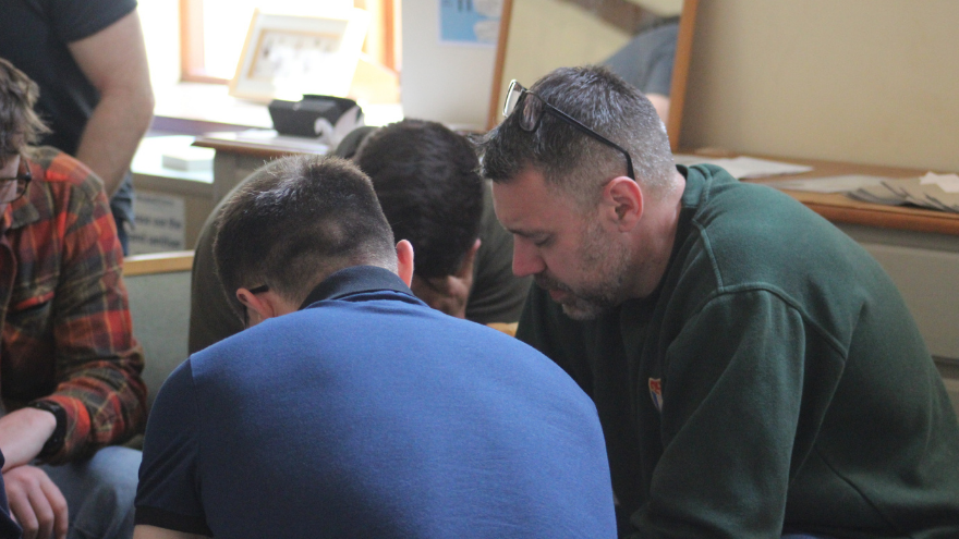 ASR Steve Curley praying in a circle with a group of soldiers at Equip