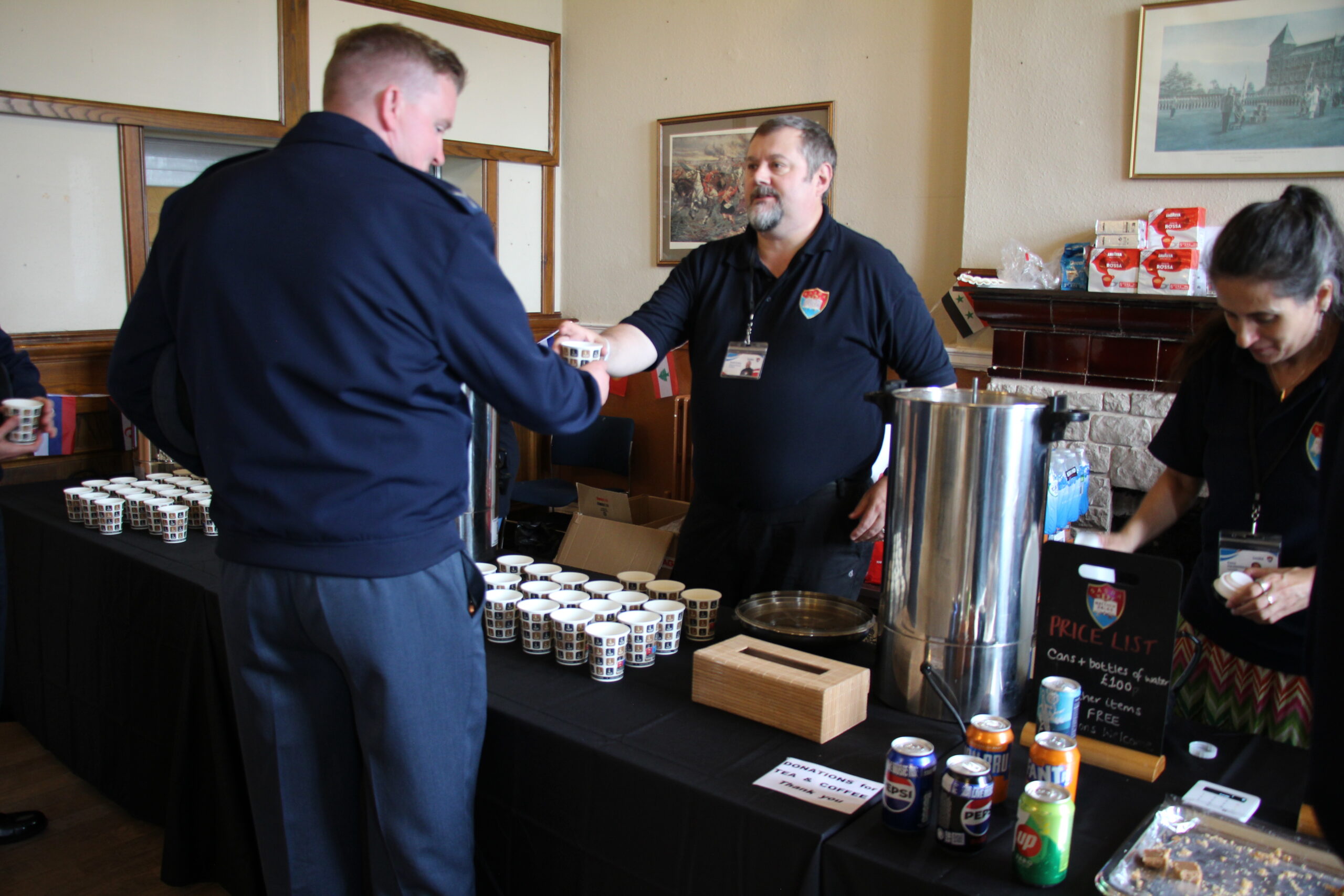 Regional Manager Keith Evans handing a performer a hot drink at the Tattoo